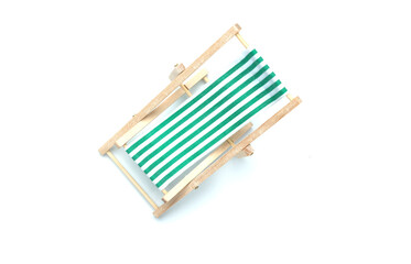 A flatlay picture of folding beach chair on white background.  Retirement plan and vacation concept.
