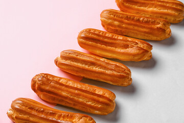 Row of sweet eclairs on color background