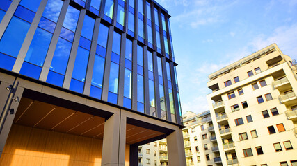 Glass modern building with blue sky background. Low angle view and architecture details. Urban...