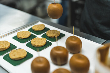 Apple-shaped cakes are placed on a rack by baking expert. Work with precision. Blurred foreground. High quality photo