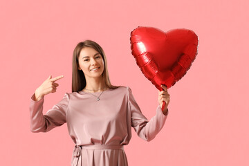 Young woman with balloon for Valentine's Day on pink background