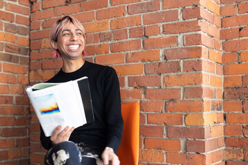 Non-binary person reading outside.