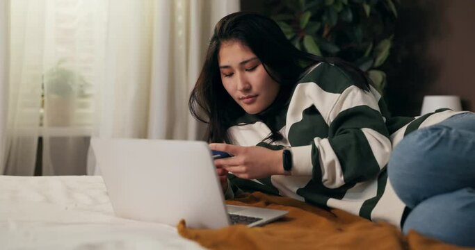 The cheerful woman makes online payments for purchases on the store's website. The girl uses a discount code that gives her a big discount, she is happy delighted.