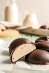 Parchment with delicious bird's milk candies on table, closeup