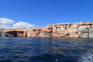 Fototapeta na wymiar Water splashing from a watercraft and Colorful sandstone rock formations along the Colorado River at Glen Canyon National Recreation Area 