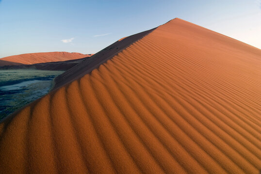 Sossusuvelei, NAMBIA - JANUARY (3): Giant sand dunes basked in evening light enclose the huge clay pan known as Sossusuvlei