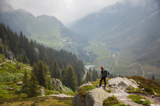 A woman looks out over G&Atilde;&para;schenertal from the hiking trail to Bergsee, Uri, Switzerland.