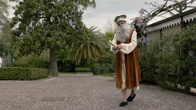 Leonardo Da Vinci , bellissimo cosplay che cammina e legge una pergamena in una villa di Firenze