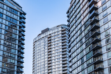 Obraz premium Modern new apartment building. Multistoried new living block of flats. Modern apartments with balconies and blue sky