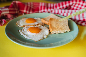 A top down and side view of eggs on the plate with toast bread on the side for breakfast clean meal healthy food 