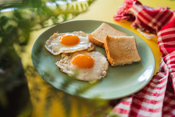 A top down and side view of eggs on the plate with toast bread on the side for breakfast clean meal healthy food 