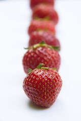 Raw of juicy strawberries on a white background