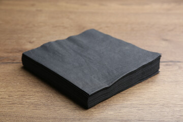 Stack of black clean paper tissues on wooden table