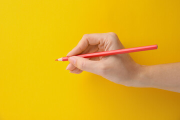 Woman with red pencil on yellow background, closeup
