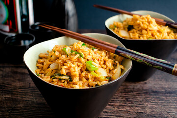 Kimchi Fried Rice With Chopsticks Resting on the Bowls: Two bowls of Korean kimchi bokkeumbap made with fermented cabbage