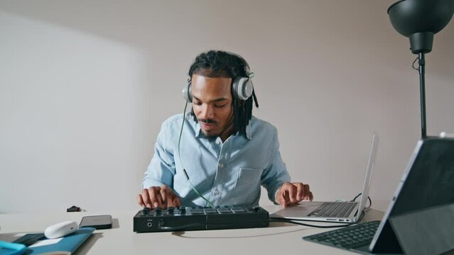 Headphones man using controller apartment closeup. Music producer working home