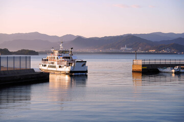Fototapeta premium 早朝の能古港に入港する福岡市営渡船「レインボーのこ」