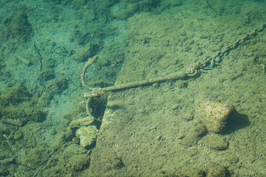 Photo of an anchor and chain underwater near the fishing village of Naoussa on the Greek island of Paros.
