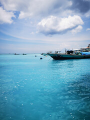 Boote im strahlend blauen und klaren Meer vor den Gili Inseln, Gili Trawangan, Indonesien
