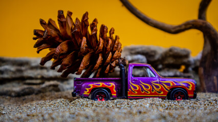 Fototapeta premium toy car hauling pinecones on an orange background