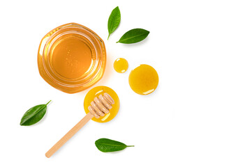 Jar of honey with dipper and leaves on white background. Top view
