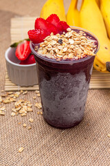 Acai in a glass with strawberry, banana and granola. Brazilian food.