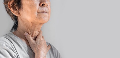 Pain at neck of Asian woman. Concept of sore throat, pharyngitis, laryngitis, thyroiditis, or...