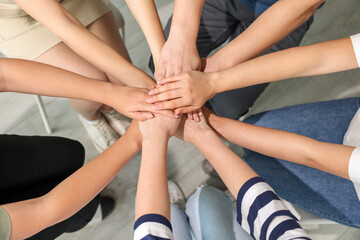 Group of people holding hands together indoors, above view. Unity concept