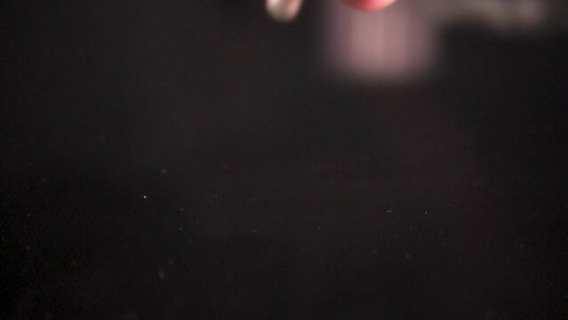 The man drops pills from his hand, enzyme, pancreatic treatment. Close-up shot on a black surface. Slowmotion. Scene A.