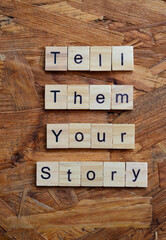 tell them your story text on wooden square, motivation quotes