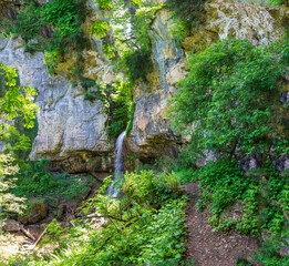 Fototapeta na wymiar waterfall, cascade of a mountain river in a stone bed, summer season,panoramic view.
