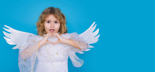 Little angel. Portrait of cute kid with angel wings isolated on blue studio isolated background. Little angel, valentines day. Banner header, copy space. Angelic kids.