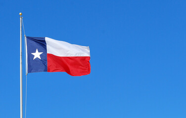 Fototapeta na wymiar Texas flag high in the sky outdoors.
