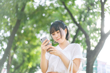 Fototapeta premium Young adult southeast asian business single woman using smartphone talking with friend happy face and laugh