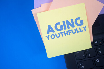 Aging Youthfully. Text on adhesive note paper. Event, celebration reminder message.