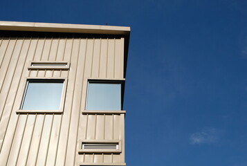 Rectangular windows on cream building facade against blue sky