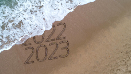 New year 2023 handwritten in the sand surface