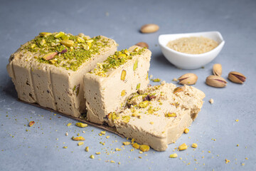 Sesame halva with pistachios on grey background. Top view. Copy space. Traditional middle eastern sweets. Jewish, turkish, arabic national dessert. Turkish delight.
