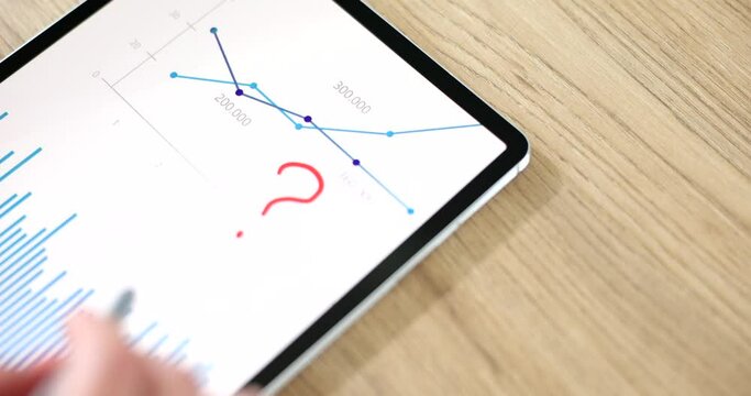 Marketer analyst draws question marks on chart analytics tablet computer