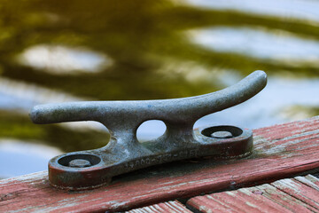 Dock cleat on a dock with blurred water in the background