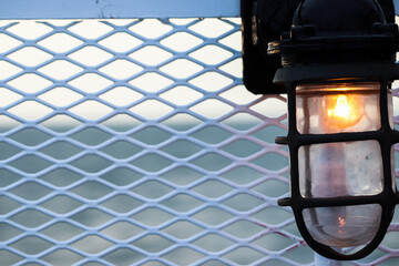 Vintage light on a mesh metal wall with the ocean blurred in the background