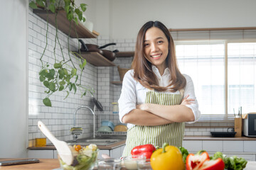 Portrait of attractive asian japanese woman in kitchen at home, young girl browsing website on tutor cooking class and doing for kitchen, cutting vegetables, cooking, cooking concept.