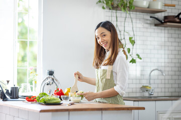 Portrait of attractive asian japanese woman in kitchen at home, young girl browsing website on tutor cooking class and doing for kitchen, cutting vegetables, cooking, cooking concept.