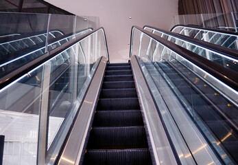 Fototapeta premium Empty escalator with led lighting on the sides at a shopping mall 