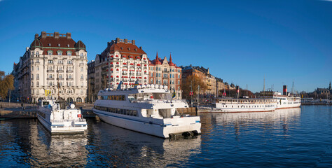 Moored boats at the pier Strandvägen in the bay Ladugårdsviken, a low winter solstice a sunny and...