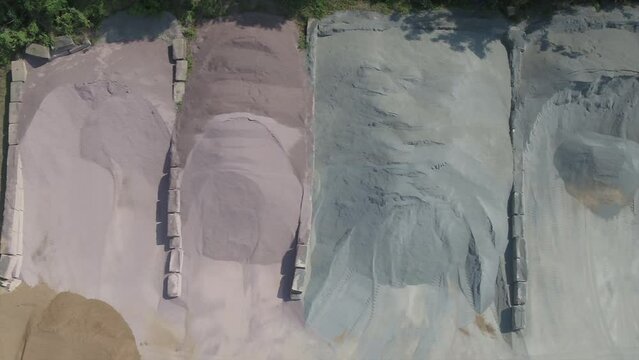 Sand and stone piles used in the production of asphalt at an asphalt plant.