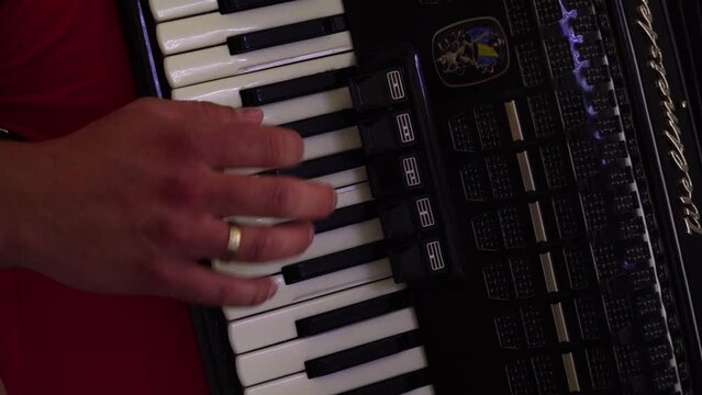closeup shot of man playing accordion outside in garden