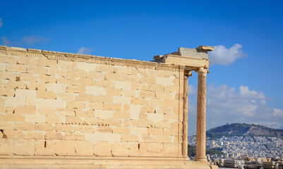 View of the marble wall of the Temple of Erechtheion on the Acropolis hill against the blue sky