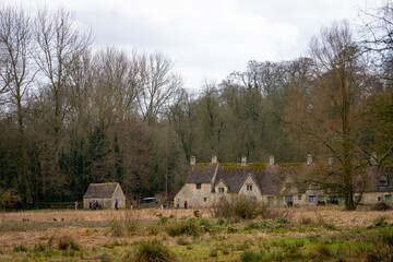 Fototapeta premium Arlington Row in Bibury , classic villages in Cotwolds wonderful stone buildings and river coln during winter cloudy day at Gloucestershire , United Kingdom : 6 March 2018