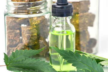 .Glass bottle of cannabis oil and a jar of dried cannabis on a white background. CBD Hemp oil,hemp oil, Medical marijuana products including cannabis leaf, cbd and hash oil, alternative medicine